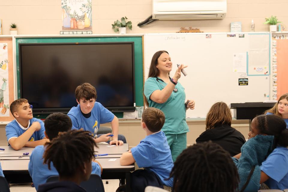 Rhonda Foster, a certified pediatric nurse practitioner, talks to eighth-graders at Poland Junior High School on Oct. 11 about her career and the instruments she uses during a typical day.