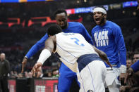 Dallas Mavericks guard Kyrie Irving, left, celebrates with teammates after scoring during the first half of an NBA basketball game against the Los Angeles Clippers Wednesday, Feb. 8, 2023, in Los Angeles. (AP Photo/Mark J. Terrill)