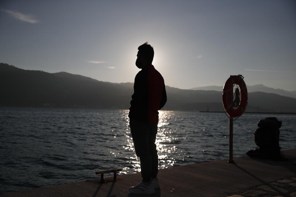 An Afghan father stands at the port of Vathy on the eastern Aegean island of Samos, Greece, Monday, Feb. 22, 2021. On a hill above a small island village, the sparkling blue of the Aegean just visible through the pine trees, lies a boy’s grave. His first ever boat ride was to be his last - the sea claimed him before his sixth birthday. His 25-year-old father, like so many before him, had hoped for a better life in Europe, far from the violence of his native Afghanistan. But his dreams were dashed on the rocks of Samos, a picturesque Greek island almost touching the Turkish coast. Still devastated from losing his only child, the father has now found himself charged with a felony count of child endangerment. (AP Photo/Thanassis Stavrakis)