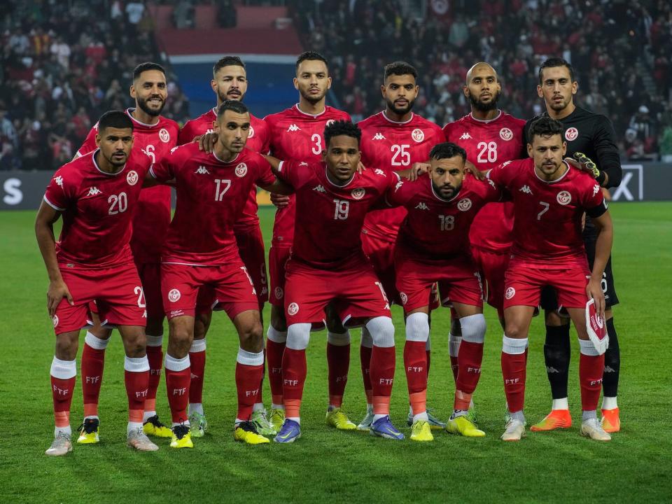 The Tunisia soccer team poses with their arms wrapped around each other before a match.