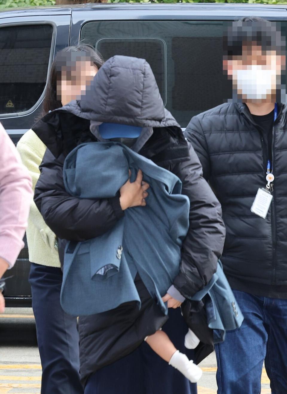涉嫌恐嚇韓星李善均並拿到5,000萬元的28歲A女，今（28日）抱著小孩現身韓國仁川地方法院。（翻攝newsis網站）