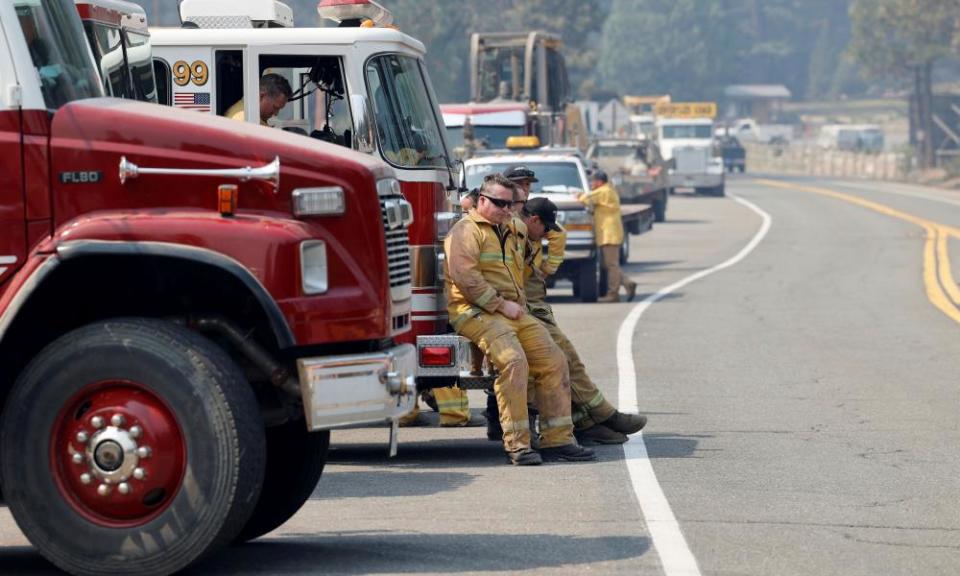 firefighters sitting against a truck on a highway