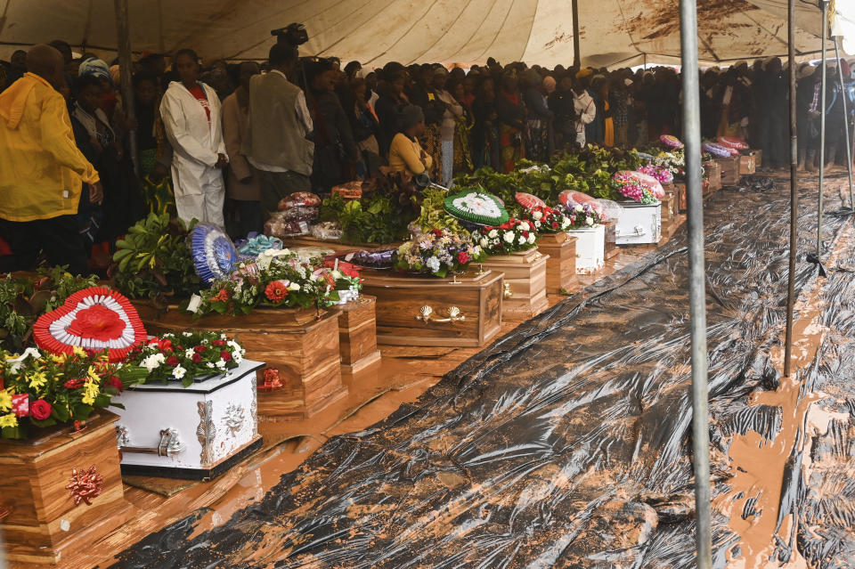 People attend the burial ceremony of some of the people who lost their lives following heavy rains caused by Cyclone Freddy in Blantyre, southern Malawi, Wednesday, March 15, 2023. After barreling through Mozambique and Malawi since late last week and killing hundreds and displacing thousands more, the cyclone is set to move away from land bringing some relief to regions who have been ravaged by torrential rain and powerful winds. AP Photo/Thoko Chikondi)