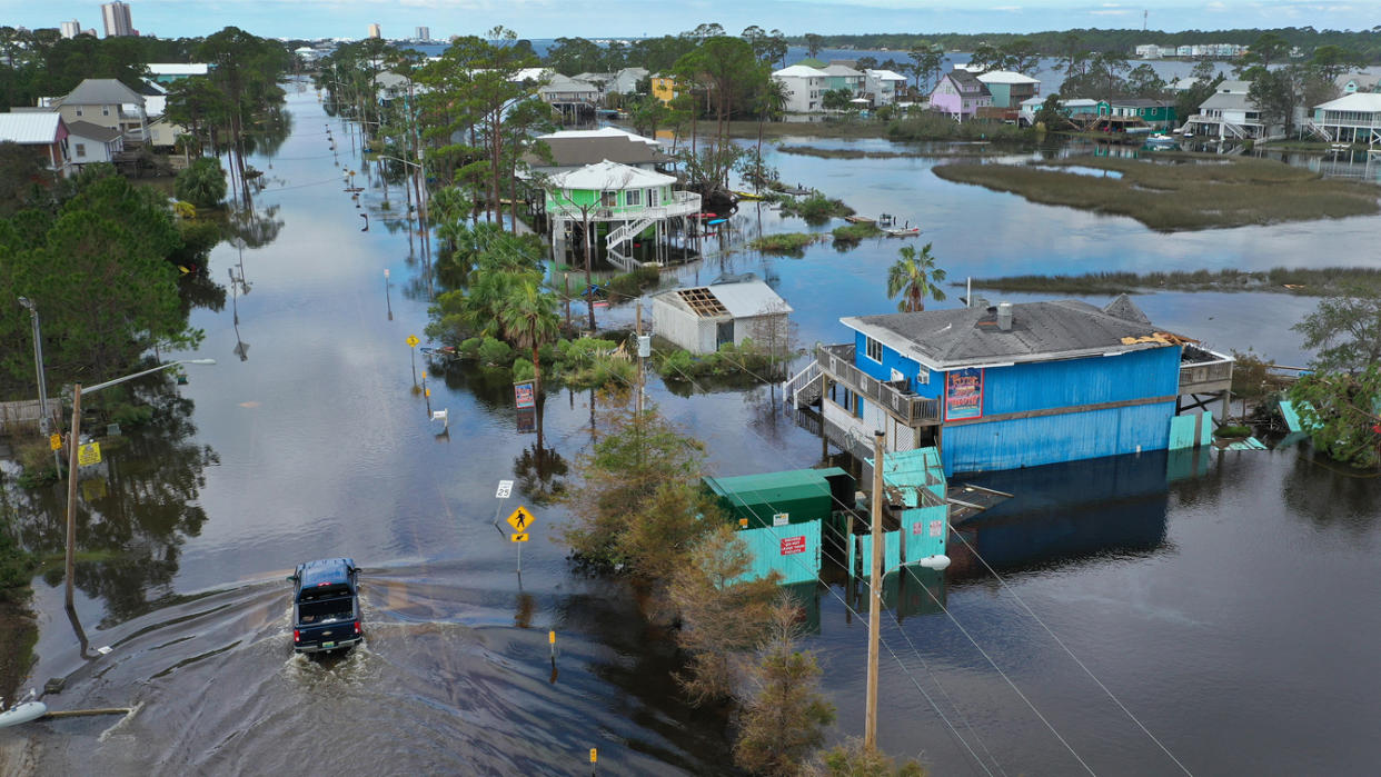 A vehicle passes through a flooded street after Hurricane Sally 