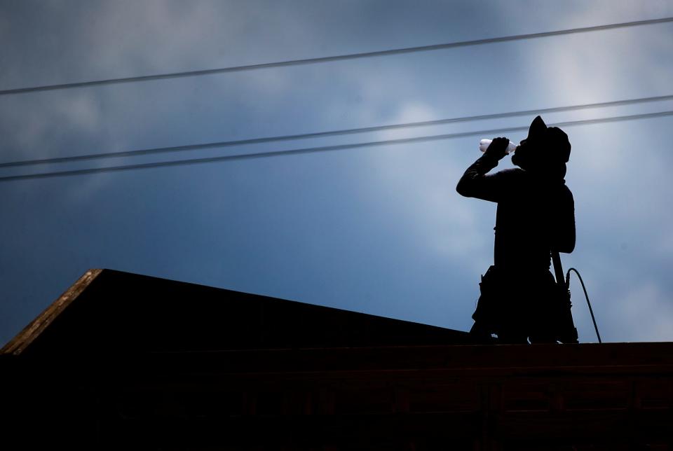 A worker takes a drink of water while framing a new home in Montopolis in 2016. OSHA has developed proposed safety standards for those working in the heat, but finalizing such rules could take a few more years.