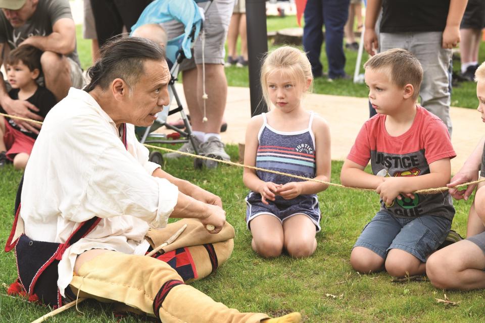 Youngsters listen to an artesian at the 2022 Chuck Wagon Festival at the National Cowboy & Western Heritage Museum in Oklahoma City.