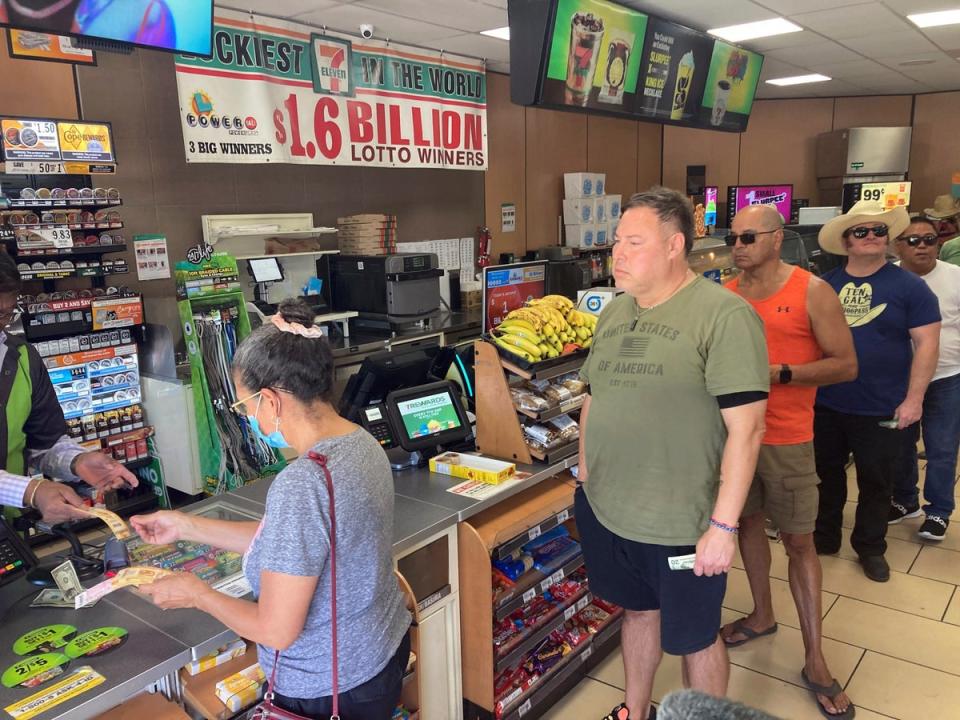 People line up to buy Powerball tickets at a 7 Eleven liquor store (AP)