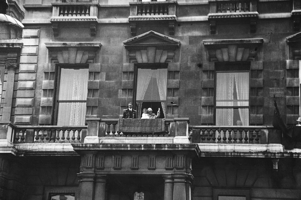 27th June 1927: George, Duke of York and Elizabeth, Duchess of York acknowledging the cheers of a crowd from the balcony of their home at 145 Piccadilly, London.