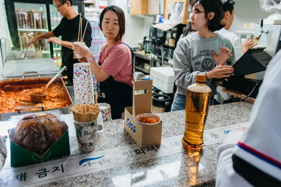 Un vendedor de “tteokbokki” (pasteles de arroz picantes), “eomuk” (pasteles de pescado), “sundae” (salchicha con arroz y verduras) y cerveza de barril durante un partido de exhibición entre la selección nacional de béisbol de Corea del Sur y los Padres de San Diego en el Gocheok SkyDome en Seúl, Corea del Sur, el 17 de marzo de 2024. (Jun Michael Park/The New York Times)