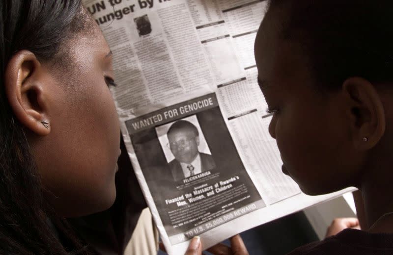 FILE PHOTO: READERS LOOK AT A PICTURE OF A RWANDAN WANTED FOR ALLEGED ROLE IN RWANDA'S 1994 GENOCIDE.
