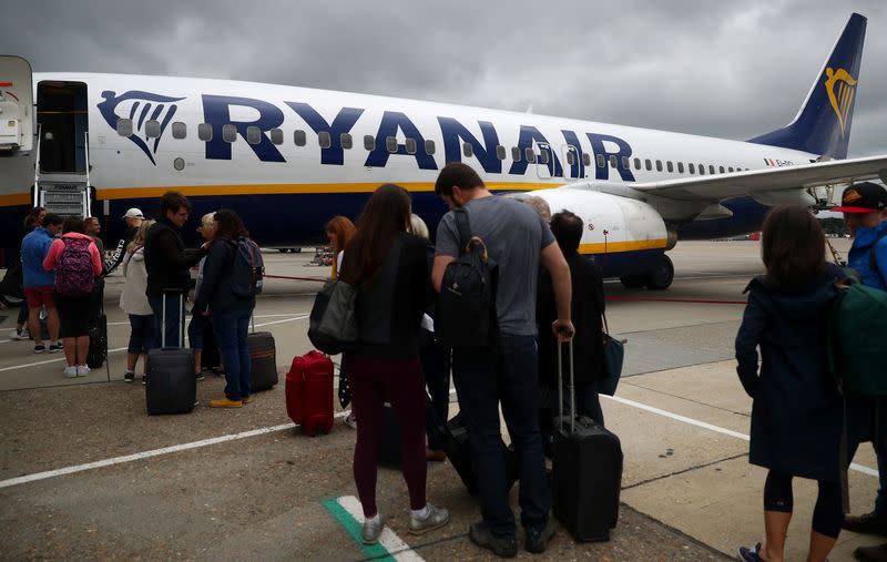 Passengers wait to board a Ryanair flight at Gatwick Airport in London