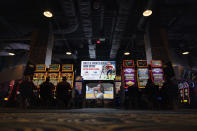 A huge TV screen at the entrance of Churchill's Bourbon & Brew Bar & Grille, flanked by electronic gaming machines, promotes sports betting at Turfway Park Racing & Gaming, Friday, Dec. 22, 2023, in Florence, Ky. Sports betting has spread rapidly across U.S. states in the past five years. But the odds for further expansion may be fading as state legislatures prepare to return to work in 2024. (AP Photo/Carolyn Kaster)