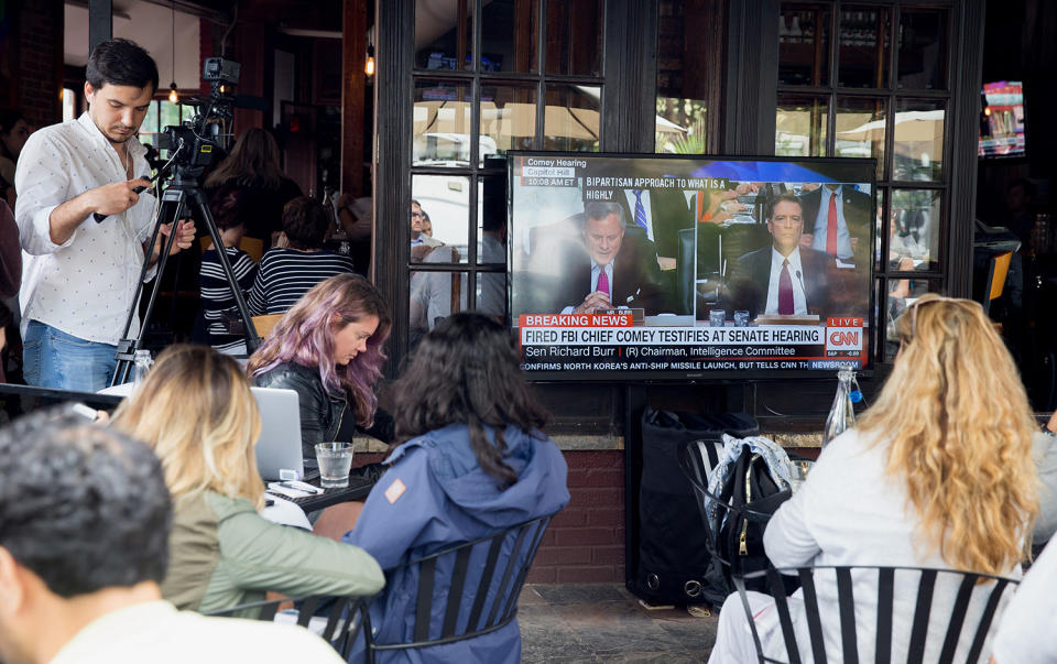 <p>People watch Former FBI Director James Comey testimony before the Senate Intelligence Committee on Capitol Hill at Shaw’s Bar in Washington, D.C., June 8, 2017. (Tasos Katopodis/EPA) </p>