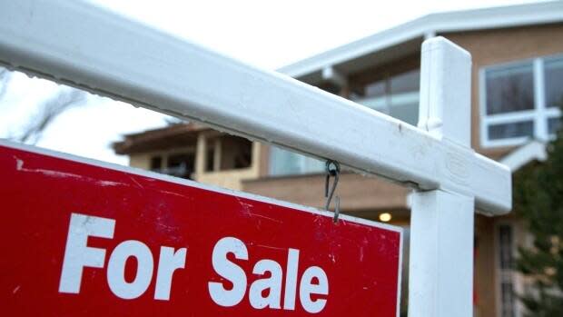 A sign advertises a house for sale in Calgary in this file photo. The pandemic adversely affected major centres across the country, and Calgary was no exception, CMHC says. (Robson Fletcher/CBC - image credit)