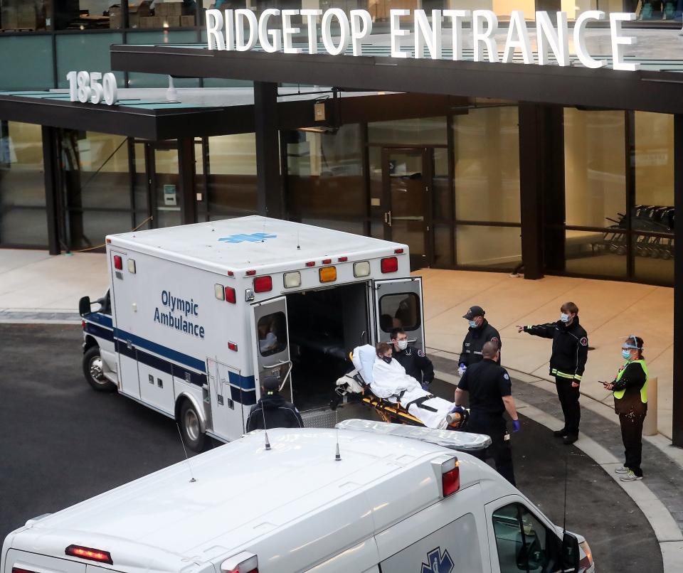 FILE PHOTO - An Olympic Ambulance crew unloads a patient from Harrison at the Ridgetop Entrance of St. Michael Medical Center in Silverdale in December 2020.