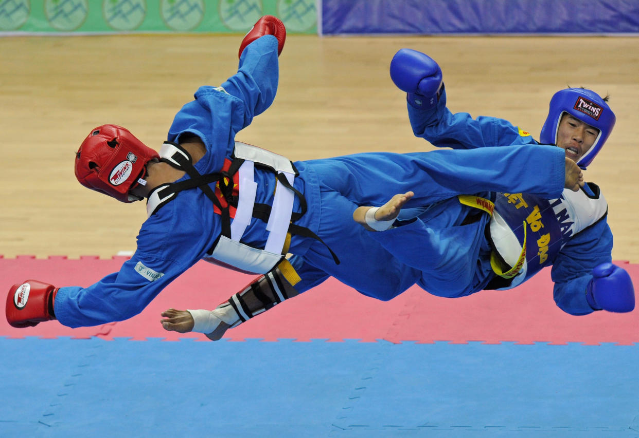 Soukanh Taypanyavong (R) of Laos competes against Tran Anh Tuan (L) of Vietnam during the men's vovinam final 55 kg final at Zeyar Thiri stadium during the 27th Southeast Asian SEA Games in Naypyidaw on December 20, 2013. Nguyen Soukanh Taypanyavong won the gold medal. AFP PHOTO / SOE THAN WIN        (Photo credit should read Soe Than WIN/AFP via Getty Images)