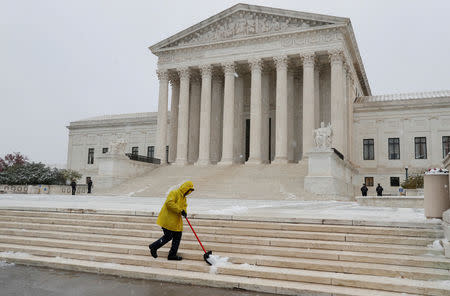 FILE PHOTO: A worker clears snow from the steps outside of the U.S. Supreme Court in Washington, U.S., November 15, 2018. REUTERS/Leah Millis