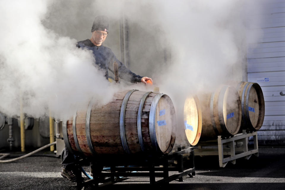 In this photo taken Thursday, Nov. 21, 2019, cellar master Jim Hewitson applies steam to wine barrels to hydrate and seal them before wine is added at Patterson Cellars winery in Woodinville, Wash. Washington, which now boasts more than 1,000 wineries in the state, has become a force in the wine industry. The state is the second-largest producer of premium wines in the United States, trailing only California. (AP Photo/Elaine Thompson)