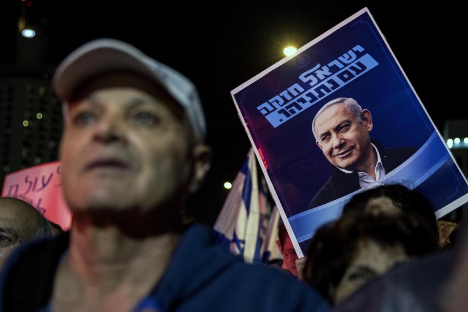 Supporters of the Israeli Prime Minister Benjamin Netanyahu rally outside Israel's parliament in Jerusalem, Wednesday, Dec. 11, 2019. The Israeli parliament began voting to dissolve itself on Wednesday and pave the path to an unprecedented third election within a year. Hebrew in posters reads: "Netanyahu Israel is strong." (AP Photo/Tsafrir Abayov)