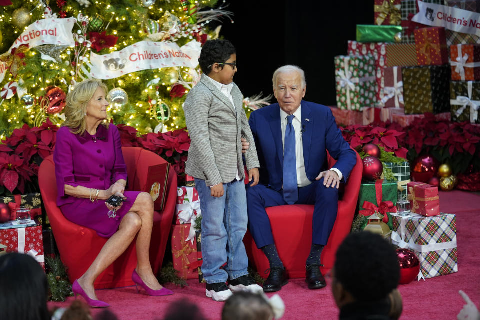 Sumukh Arunkumar, 10, stands next to President Joe Biden as he speaks after first lady Jill Biden read "Twas the Night Before Christmas" to patients at Children's National Hospital, Friday, Dec. 22, 2023, in Washington. (AP Photo/Evan Vucci)