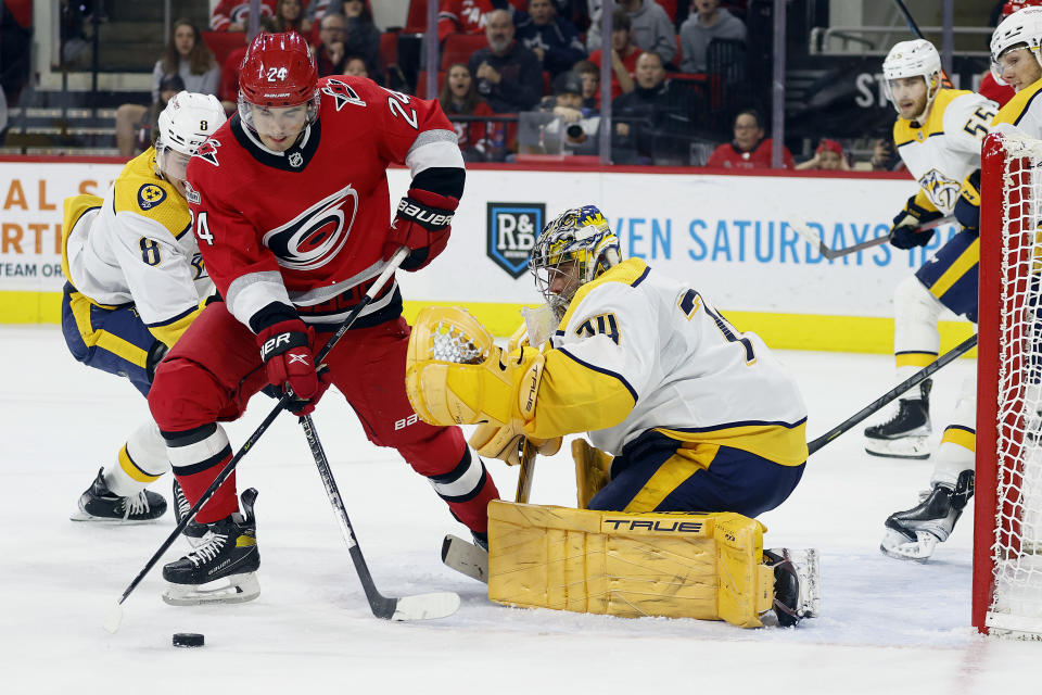 Carolina Hurricanes' Seth Jarvis (24) controls the puck in front of Nashville Predators goaltender Juuse Saros (74) during the second period of an NHL hockey game in Raleigh, N.C., Thursday, Jan. 5, 2023. (AP Photo/Karl B DeBlaker)