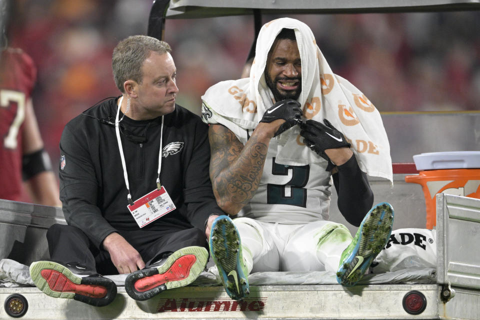 Philadelphia Eagles cornerback Darius Slay, right, sits with Dr. Tony DeFalco as he is carted off the field during the second half of an NFL wild-card playoff football game against the Tampa Bay Buccaneers, Monday, Jan. 15, 2024, in Tampa, Fla. The Buccaneers won 32-9. (AP Photo/Phelan M. Ebenhack)