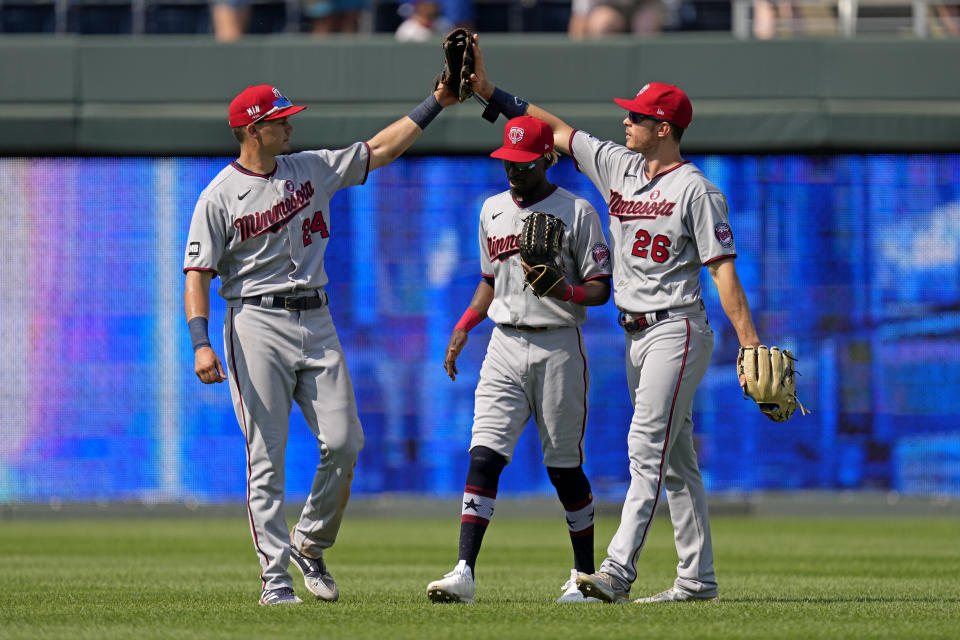 Minnesota Twins outfielders Trevor Larnach (24), Max Kepler (26) and Nick Gordon celebrate after their baseball game against the Kansas City Royals Sunday, July 4, 2021, in Kansas City, Mo. The Twins won 6-2. (AP Photo/Charlie Riedel)