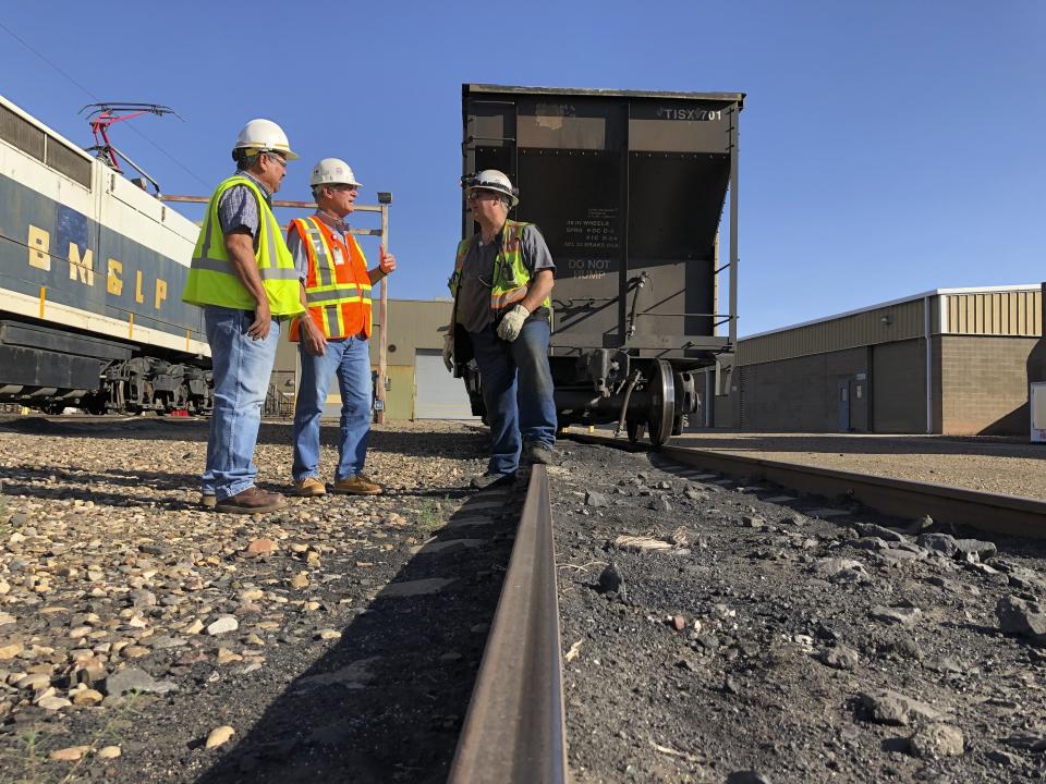 This Aug. 20, 2019, image shows workers talking about the impending closure of the Navajo Generating Station near Page, Ariz The power plant will close before the year ends, upending the lives of hundreds of mostly Native American workers who mined coal, loaded it and played a part in producing electricity that powered the American Southwest. (AP Photo/Susan Montoya Bryan)