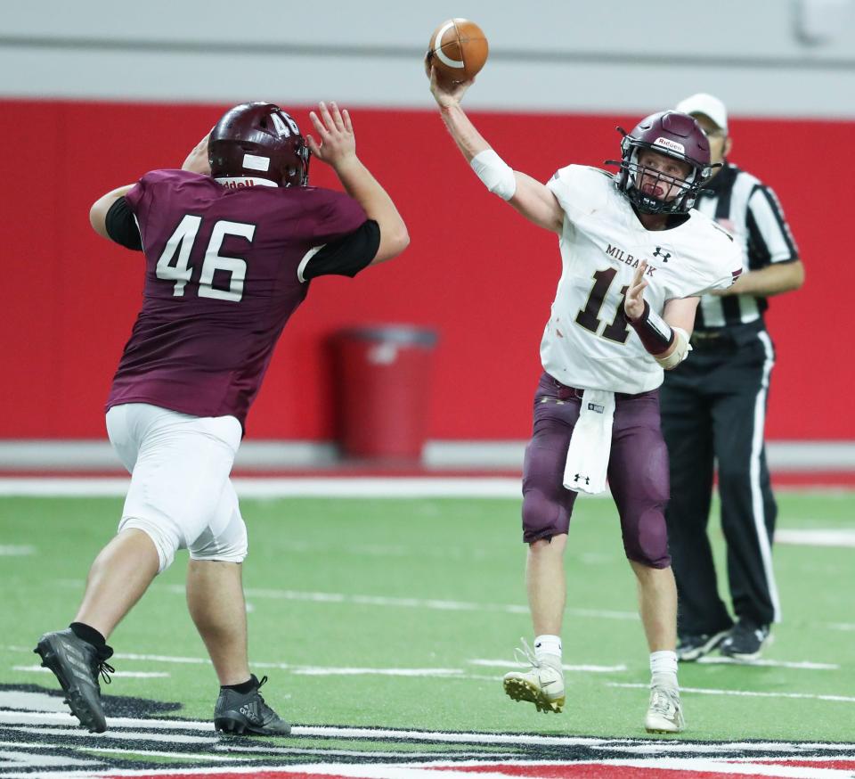 Milbank quarterback Kaden Krause (11) throws a pass over the Madison defender Parker Johnson (46) during the state Class 11A football championship Friday in the DakotaDome. Madison won 31-0.