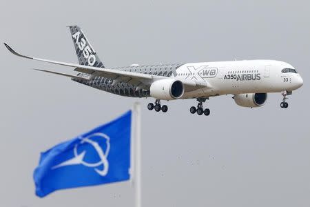 An Airbus A350 jetliner flies over Boeing flags as it lands after a flying display during the 51st Paris Air Show at Le Bourget airport near Paris, June 15, 2015. REUTERS/Pascal Rossignol/Files