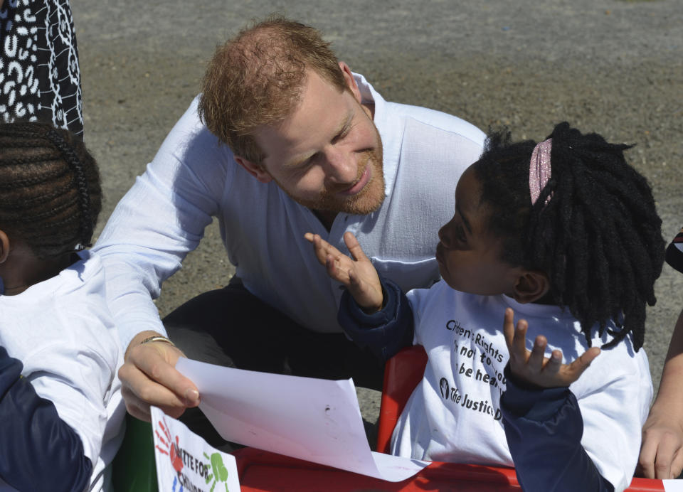His Royal Higness Prince Harry greets children on his arrival at the Nyanga Methodist Church in Cape Town, South Africa, Monday, Sept, 23, 2019, which houses a project where kids are taught about their rights, self-awareness and safety, and are provided self-defence classes and female empowerment training to young girls in the community. The royal couple are starting their first official tour as a family with their infant son, Archie (Courtney Africa / Africa News Agency via AP, Pool)
