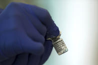 A medical worker holds a Pfizer-BioNTech COVID-19 vaccine at Tokyo Medical Center in Tokyo Wednesday, Feb. 17, 2021. Japan's first coronavirus shots were given to health workers Wednesday, beginning a vaccination campaign considered crucial to holding the already delayed Tokyo Olympics. (Behrouz Mehri/Pool Photo via AP)