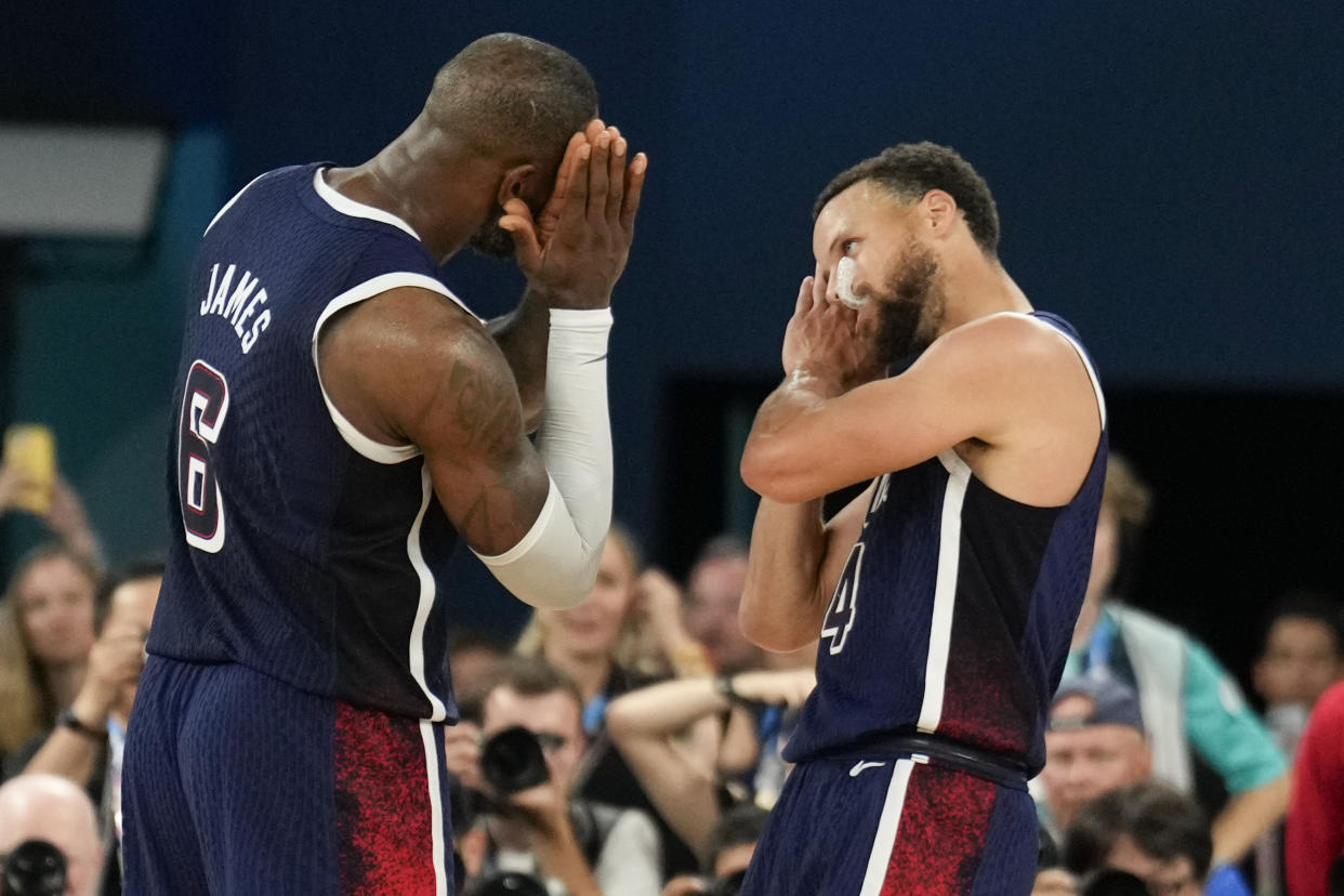 FILE - United States' Stephen Curry (4) and LeBron James (6) celebrate after beating France to win the gold medal during a men's gold medal basketball game at Bercy Arena at the 2024 Summer Olympics, Aug. 10, 2024, in Paris, France. (AP Photo/Mark J. Terrill, File)