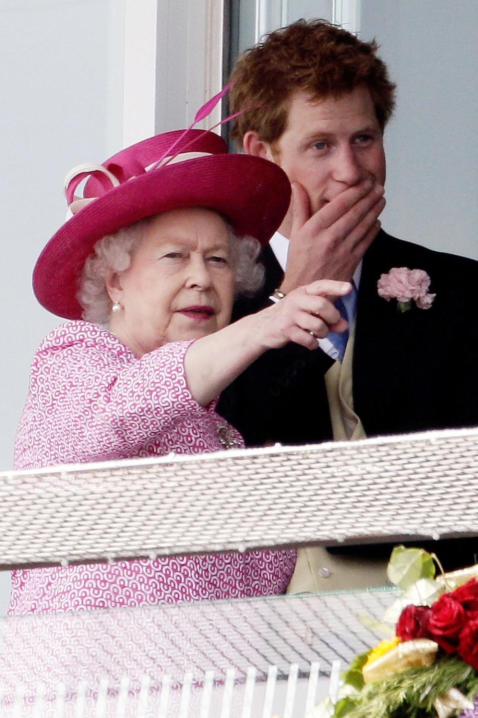 They've got their game faces on. Queen Elizabeth and Prince Harry watch a race at Epsom Downs Racecourse on Derby Day in 2011. 