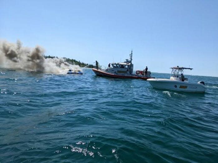 The Coast Guard attempt to put out a power boat fire near Charlevoix on Saturday.