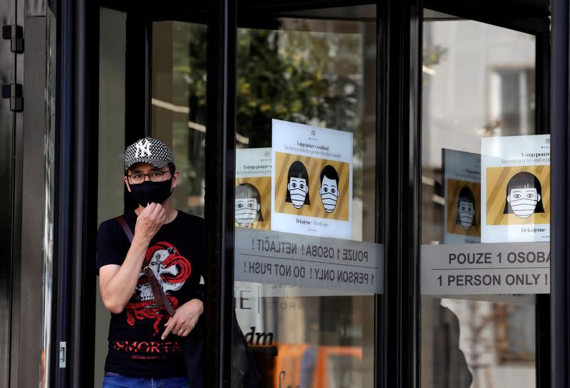 FILE PHOTO: A man wearing a face mask leaves a shopping mall in Prague