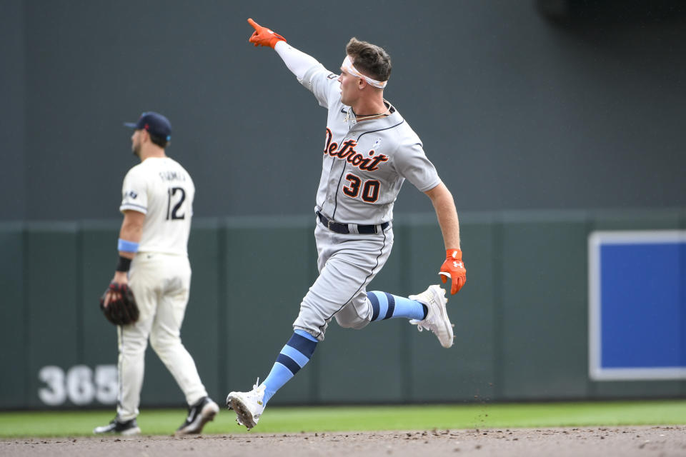 Detroit Tigers' Kerry Carpenter points in the direction of his home run ball as he rounds the bases past Minnesota Twins second baseman Kyle Farmer (12) during the fifth inning of a baseball game, Sunday, June 18, 2023, in Minneapolis. (AP Photo/Craig Lassig)
