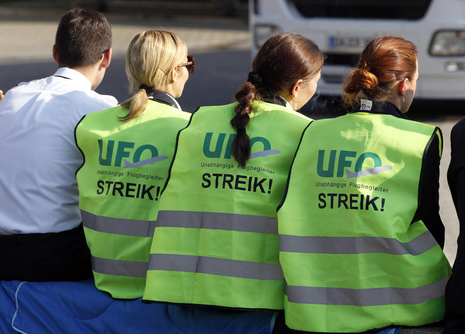 Crew members of the Lufthansa airline are pictured during a six hours strike at the Tegel Airport in Berlin, Germany, Tuesday, Sept. 4, 2012. A union representing Lufthansa flight attendants escalated a bitter pay dispute on Tuesday, calling members out on strike at three German airports _ including the two biggest, Frankfurt and Munich _ in a showdown with an airline determined to bring down costs in the face of increasingly tough competition. (AP Photo/Michael Sohn)