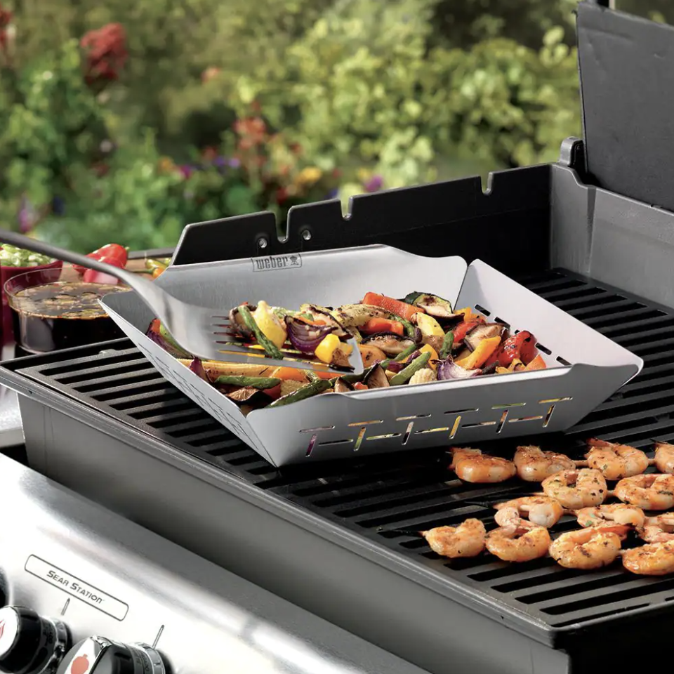 Weber Stainless Steel Grill Basket with vegetables and shrimp grilling on BBQ (Photo via The Home Depot)