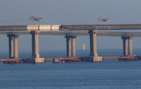 Russian jet fighters fly over a bridge connecting the Russian mainland with the Crimean Peninsula after three Ukrainian navy vessels were stopped by Russia from entering the Sea of Azov via the Kerch Strait in the Black Sea, Crimea November 25, 2018. REUTERS/Pavel Rebrov
