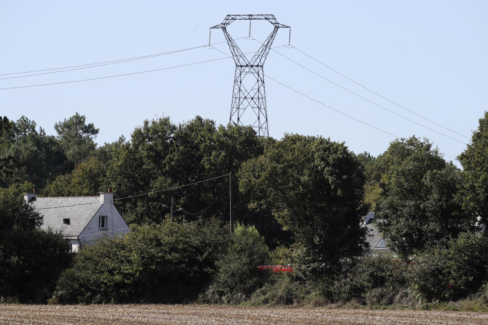 A rescue vehicle, partially hidden, parks near the site of a jet crash near Pluvigner, western France, Thursday, Sept.19, 2019. A Belgian F-16 fighter jet crashed in western France, damaging a house, setting a field ablaze and leaving a pilot suspended for two hours from a high-voltage electricity line after his parachute got caught, according to French authorities. (AP Photo/David Vincent)