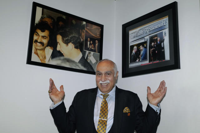 Gulu Anand, who owns Southall's Brilliant curry house and has cooked for King Charles III several times over the years when he visited the neighborhood, displays photographs of Charles in his restaurant in London, Thursday, April 27, 2023. Across London, Britain's diverse communities will come together to mark King Charles III's coronation. In south London's Brixton, musicians plan to parade through the streets entertaining crowds with a carnival set mix of Gospel, jazz, grime, disco and rap. In west London's Southall, known as “Little India,” British Indians will party with Punjabi song and dance. (AP Photo/Kirsty Wigglesworth)