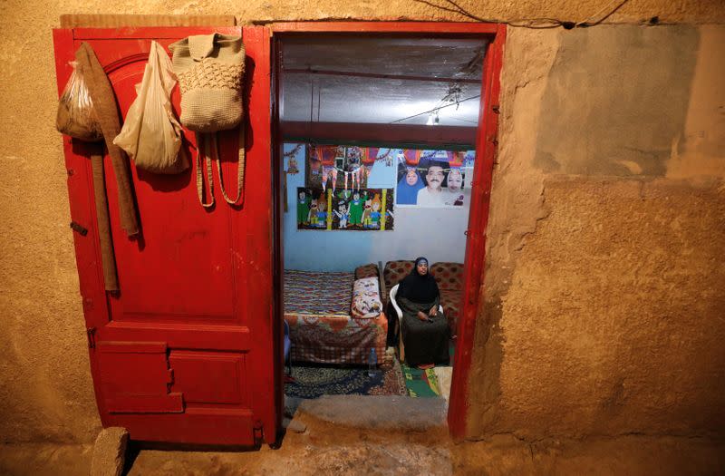 Zineb Mohamed watches television as seen from a doorway into her room in Cairo