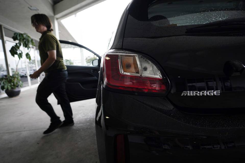 Mitsubishi sales person Matthew Boston gets out of a new Mitsubishi Mirage for sale at El Cajon Mitsubishi on Tuesday, Aug. 8, 2023, in El Cajon, Calif. At a time when auto buyers increasingly want pricey SUVs and trucks and fewer want small cars, the Mirage remains the lone new vehicle whose average sale price is under 20 grand — a figure that once marked a kind of unofficial threshold of affordability. (AP Photo/Gregory Bull)