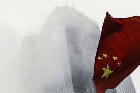 A Chinese national flag flutters in front of a construction site in Guangzhou, Guangdong province, November 7, 2014. EUTERS/Alex Lee