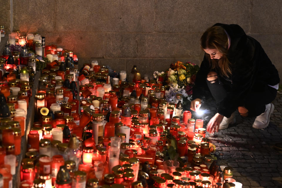 Mourners bring flowers and candles outside the building of Philosophical Faculty of Charles University in downtown Prague, Czech Republic, Saturday, Dec. 23, 2023. A lone gunman opened fire at a university on Thursday, killing more than a dozen people and injuring scores of people. (AP Photo/Denes Erdos)