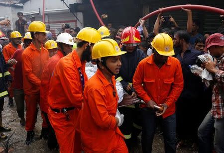 Rescue team members remove a dead body at a garment packaging factory after a fire broke out outside of Dhaka, Bangladesh, September 10, 2016. REUTERS/Mohammad Ponir Hossain