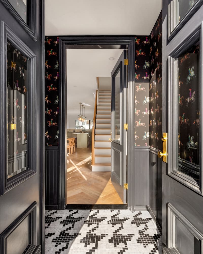 Black and white floors in wallpapered entryway.