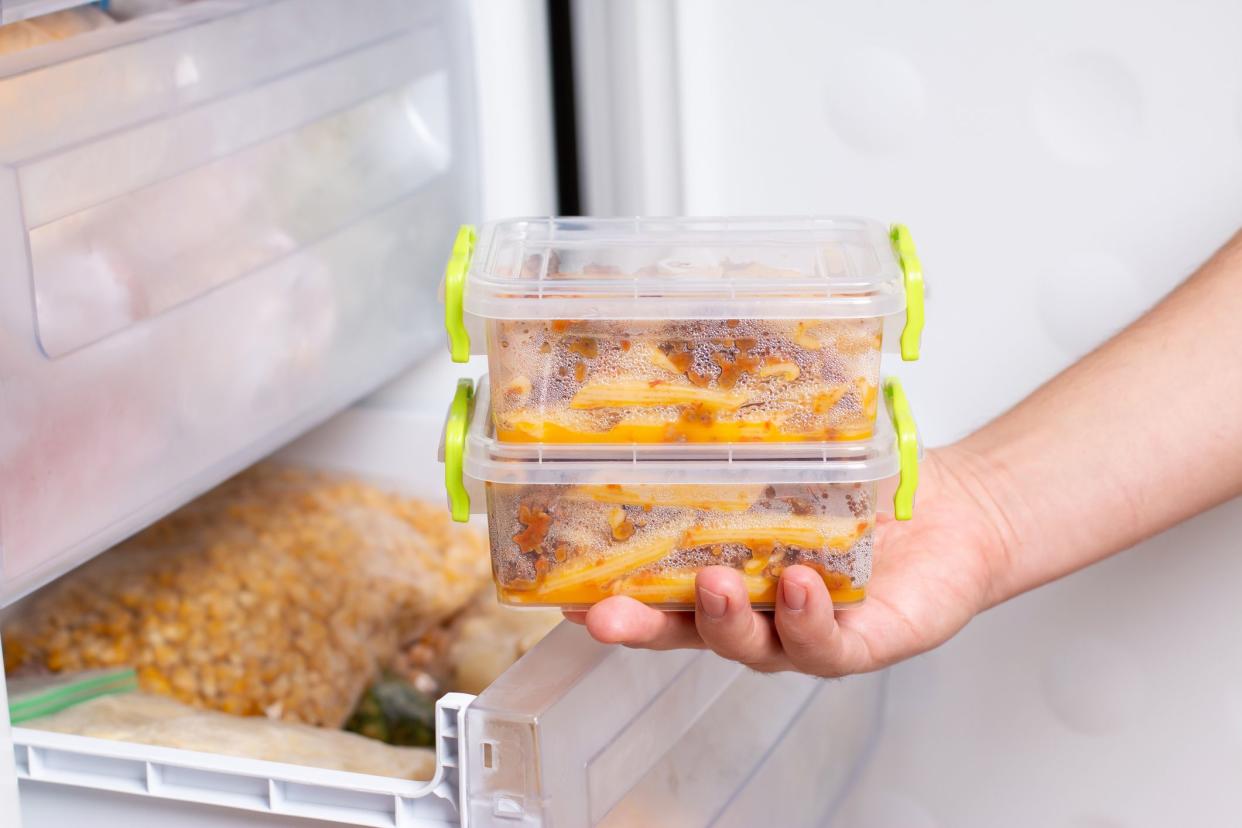 Ready frozen meal in a container in the refrigerator. Frozen food in the freezer. Fast cooking concept