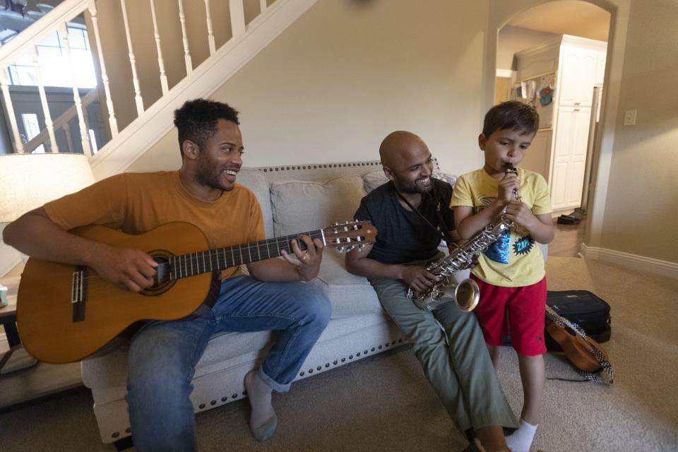 Friends since medical school, Marc Drake, left, and Jamie Jasti  would periodically make music together. They are shown with Jasti's 5-year-old son Jude at the Jasti home in Menomonee Falls.